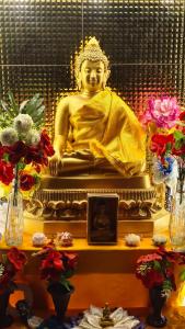 una estatua de un buddha sentado en una mesa en MONIKA MANSION Bodhgaya, en Bodh Gaya