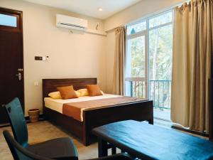 a bedroom with a bed and a large window at Lagoonai Villa in Sinimodera