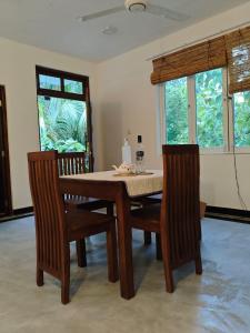a dining room with a table and two chairs at Lagoonai Villa in Sinimodera