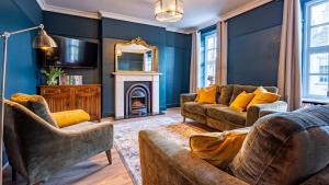 a living room with blue walls and a fireplace at Church House in Beaumaris