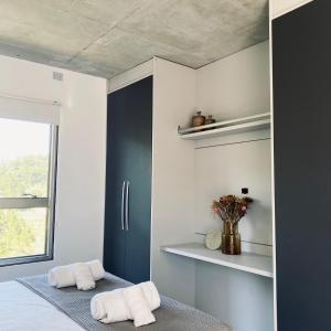 um quarto com duas toalhas sentadas numa cama em Apartamento moderno no MaxHaus Praia Brava Piscinas, Academia e Vista Verde em Itajaí