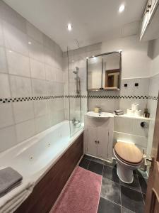 a bathroom with a tub and a toilet and a sink at Original Trafalgar Square Apartment near Buckingham Palace in London