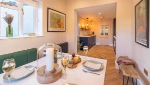 a dining room with a table with wine glasses at Church House in Beaumaris