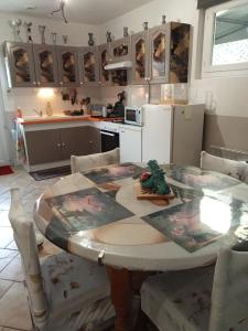 eine Küche mit Tisch und Stühlen und eine Küche mit Küche in der Unterkunft une pause quelque part au jardin des érables et des niwakis in Saint-Médard-de-Guizières + 34 Fotos