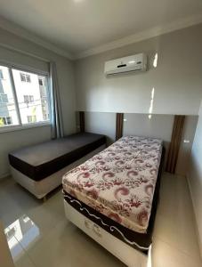 een slaapkamer met een bed en airconditioning bij Brisa do Sol Apartment 201 - Piratuba SC in Piratuba