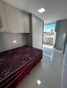 Un dormitorio con una cama y una ventana grande. en Brisa do Sol Apartment 201 - Piratuba SC, en Piratuba 9 fotos más