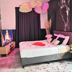 a bedroom with a bed with red flowers on it at Suite Passion - Jacuzzi privé - Table massage in Saint-Étienne