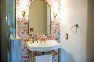 The Vintage La Mesa Tudor في Spring Valley: حمام مزود بحوض ومِرآة