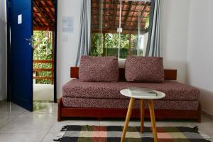 a living room with a couch and a table at Casa Matatiso - casa de 2 quartos na Ilha Grande in Angra dos Reis