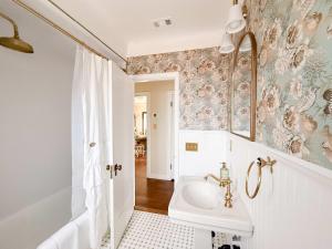 The Vintage La Mesa Tudor في Spring Valley: حمام أبيض مع حوض ومرآة