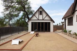 The Vintage La Mesa Tudor في Spring Valley: منزل به كرسيان أبيضان ومقعد +98 صورة