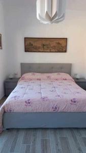 a bedroom with a bed with a pink comforter at Una terrazza sul lago in Argegno