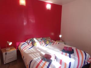 a bedroom with a red wall and a bed at La Belle Onde in Dieppe