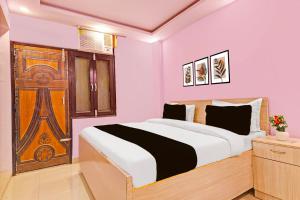 a bedroom with a bed and a wooden door at Hotel O Sky House Residency in New Delhi +23 photos
