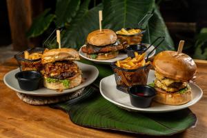 a table with three plates of sandwiches and fries at Hotel El Cielo en la Tierra in Quimbaya