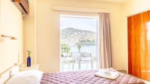 a hotel room with a bed and a balcony at Akrotopi Apartments & Studios in Tolo