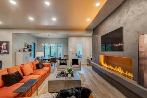 a living room with an orange couch and a fireplace at Maynard V at Elk Creek in Banner Elk
