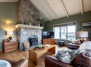a living room with a couch and a fireplace at 4 bedroom holiday home overlooking the sea in Connemara in Rossaveel