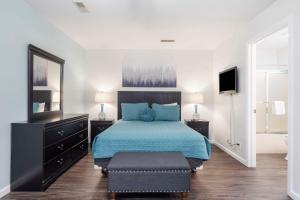 um quarto com uma cama com lençóis azuis e um espelho em Retreat by Design - Resort Amenities em Branson West