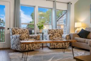 uma sala de estar com sofás, uma mesa e janelas em Retreat by Design - Resort Amenities em Branson West mais 22 fotografias