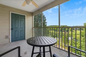 a patio with a table and a door and a balcony at Spring Creek Escape - Balcony with Views in Branson