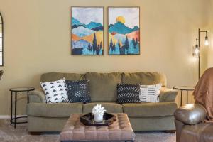 a living room with a couch and paintings on the wall at Spring Creek Escape - Balcony with Views in Branson +16 photos