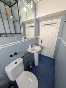 a bathroom with a toilet and a sink and a mirror at 202 - Livingtarifa Dolce Vita in Tarifa +7 photos