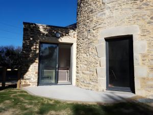 a door of a stone building with a patio at Gîte Du Moulin De La Violaye in Fay-de-Bretagne