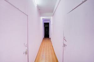 a hallway with white walls and a wooden floor at SPOT ON Prayaj In Hotel & Restaurant in Prayagraj