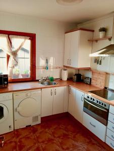 a kitchen with white cabinets and a sink at Chalet adosado entre playas in Argoños