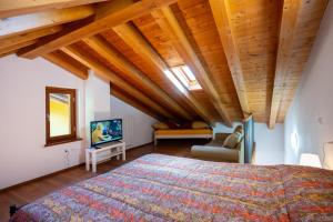 a bedroom with a large bed and wooden ceilings at Casa del Sol, Lozio Ospitar in Lozio