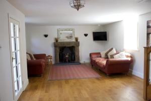 ein Wohnzimmer mit Couch und Kamin in der Unterkunft Coach House. Falcon Mews in Bude