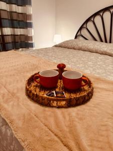 un vassoio con due tazze sopra un letto di VillettaletreGi a Campofelice di Roccella