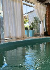 una piscina con una tenda bianca e un po' d'acqua di Studio & suites Patricia Tennis ad Abelardo Luz