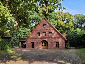 a red brick building with a clock on the top at Heidehof Kuppendorf in Kirchdorf