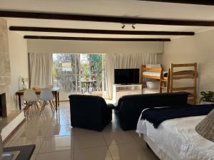 a bedroom with a bed and a living room with a television at Eagles Rest Guest House in Summerstrand