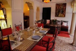 une salle à manger avec une table et un canapé dans l'établissement Riad Miliana, à Marrakech