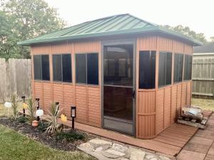 a wooden cabin with a green roof at Maple House w-Private Jacuzzi Near IAH in Humble