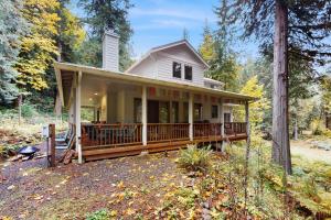 a house with a large deck in the woods at Riversong Retreat in Welches in Welches