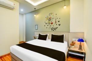 ein Schlafzimmer mit einem Bett und einer Uhr an der Wand in der Unterkunft Hotel O Palm Inn Durgapura Railway Station in Jaipur