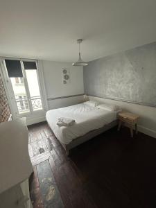 een kleine slaapkamer met een bed en een raam bij WAROUX - Appartement Rennes 6P in Rennes