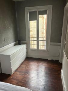 een slaapkamer met een raam en een witte dressoir bij WAROUX - Appartement Rennes 6P in Rennes +2 foto's