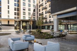 a courtyard with chairs and tables in a building at Calido Valdebebas in Madrid