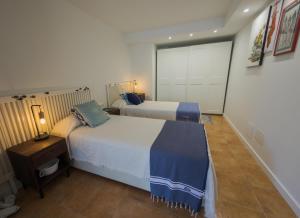 a hotel room with two beds and a night stand with a lamp at La Platjeta in Calonge +24 photos