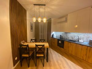 a kitchen with a wooden table and chairs in it at Apartament Bristol in Mielec