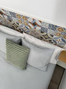 モニストロルにあるHabitación El Patufet en Casa Camí de les Aigües Monistrol de Montserratの白い枕と壁付きのヘッドボードが付いたベッド