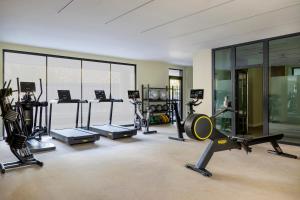 a gym with several exercise equipment in a room with windows at Calido Las Tablas in Madrid