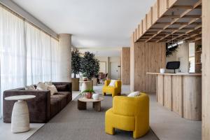 a living room with a couch and yellow chairs at Calido Las Tablas in Madrid +6 photos