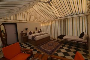 a bedroom with a bed and a couch and a chair at Kesariya Heritage Resorts in Jaisalmer +22 photos