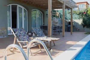 a pair of chairs sitting next to a swimming pool at La Platjeta in Calonge